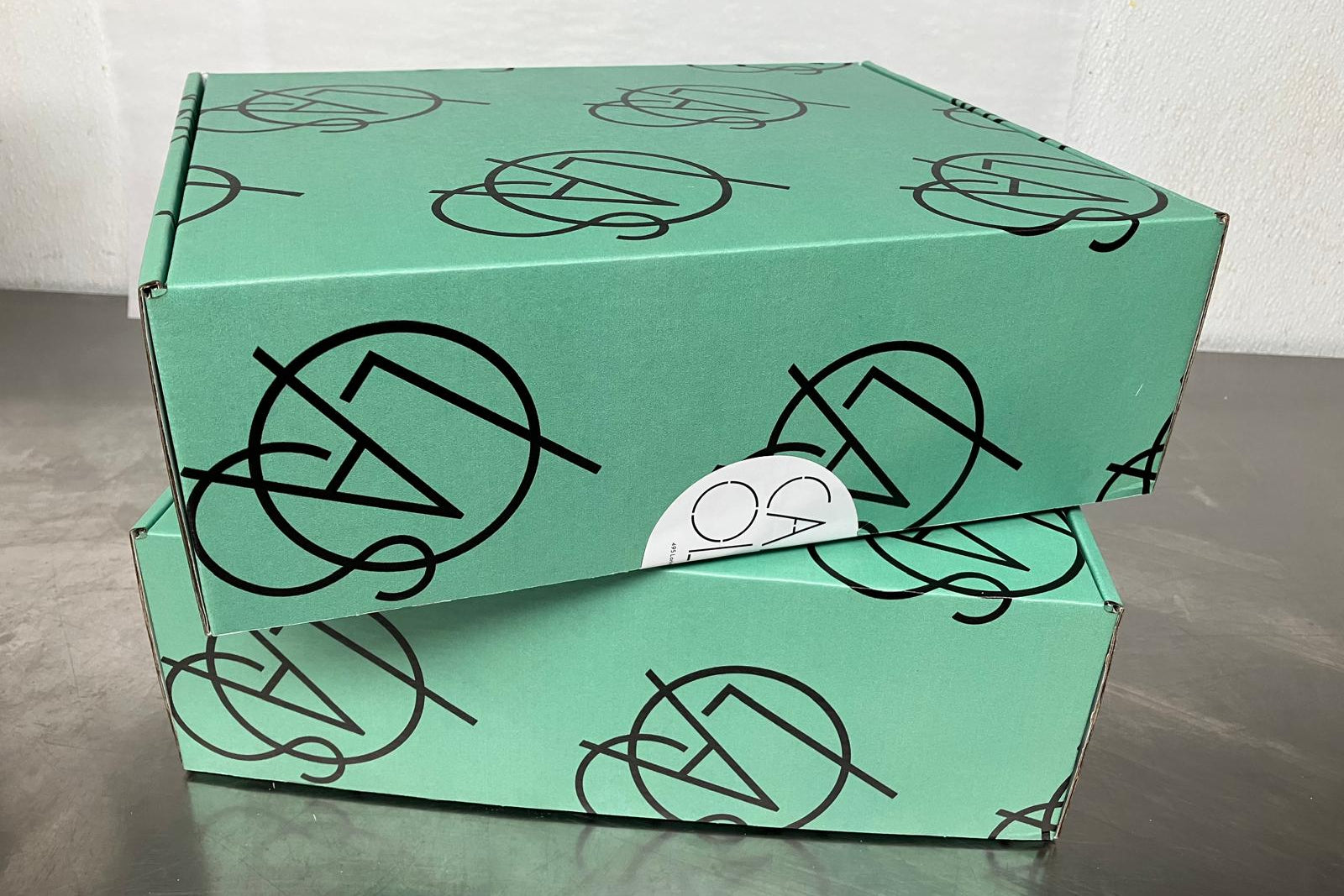 Green box with black geometric patterns on a gray surface
