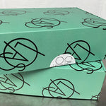 Green box with black geometric patterns on a gray surface